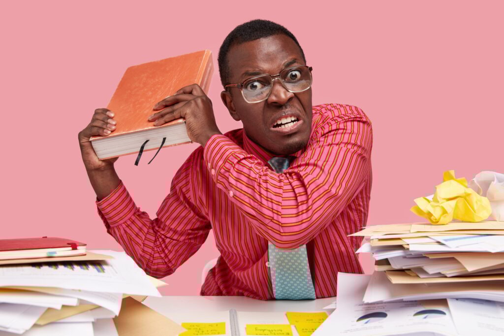 People, anger, threat concept. Irritated male teacher holds big encyclopedia, going to revenge with