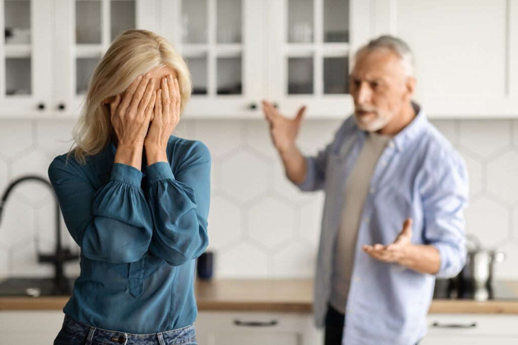 Psychological Abuse. Upset Senior Woman Crying In Kitchen While Arguing With Husband