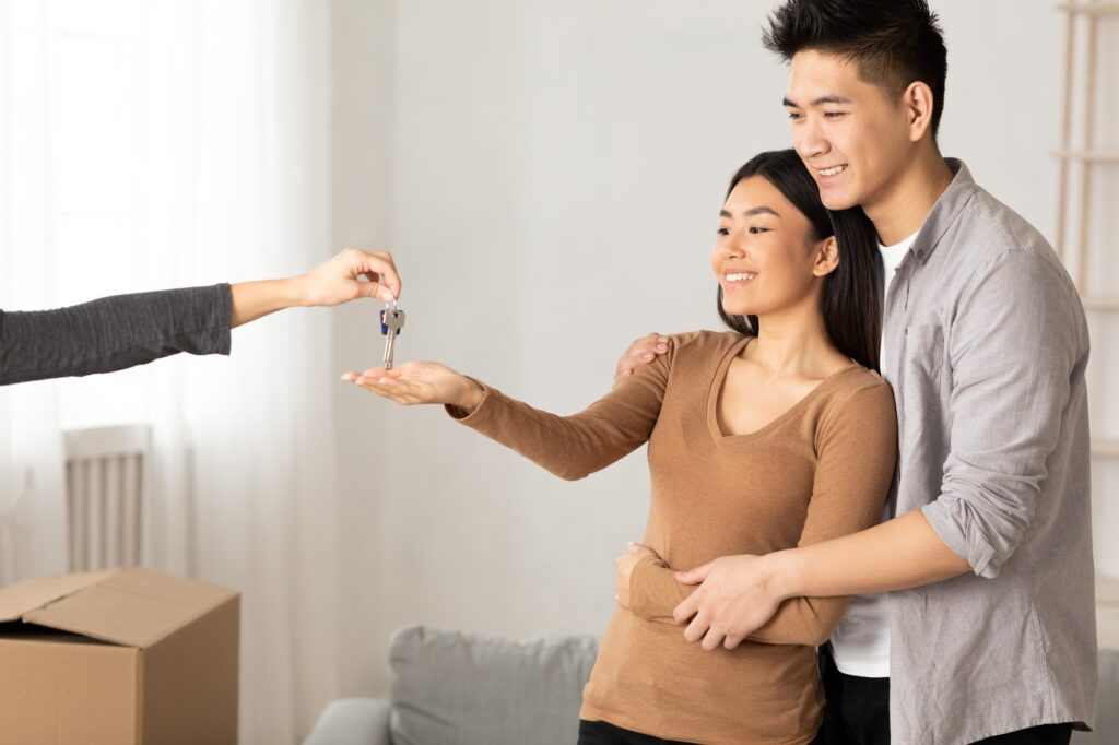 Thai man and woman receiving key from their flat