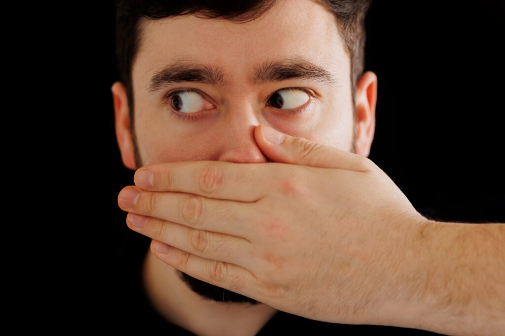 close up worried man with his hand to his mouth,